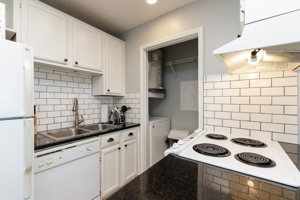 Your fully-equipped kitchen features crisp white cabinetry, classic subway tile backsplash, and everything needed to prepare home-cooked meals during your stay.
