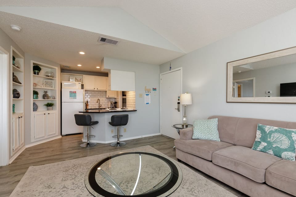 Settle into your open-concept living space where comfortable seating flows into a sleek kitchen perfect for morning coffee or evening meals together.