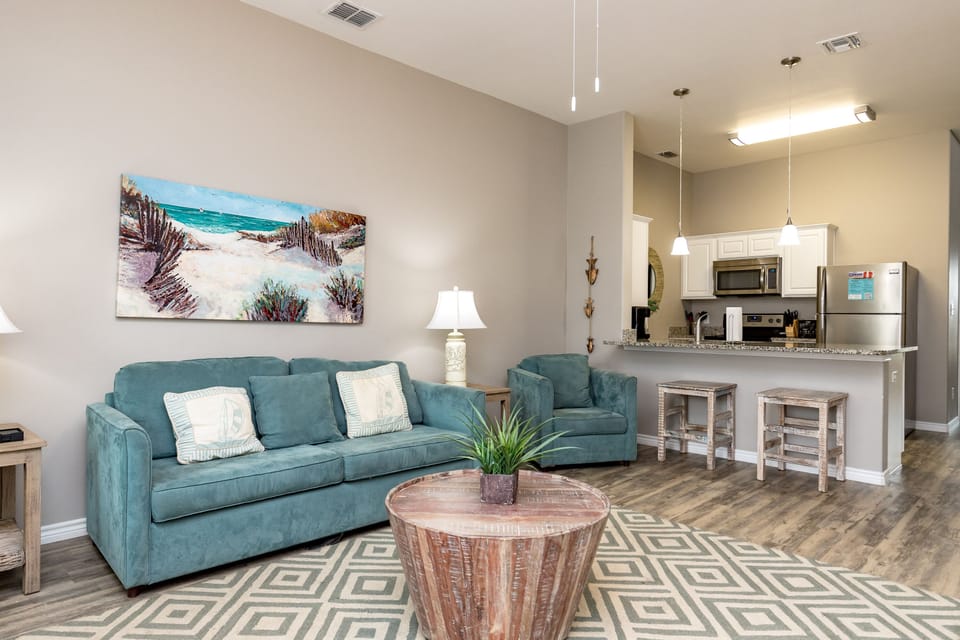 Unwind in your stylish open-concept living space with coastal charm, complete with a full kitchen and comfortable seating for memorable evenings together.