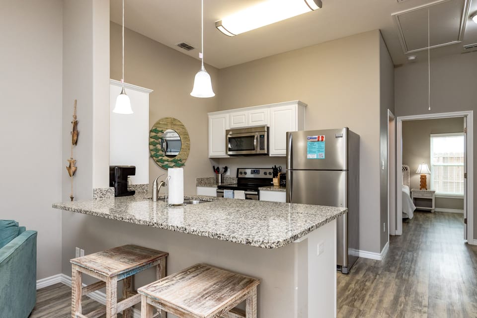 Your spacious kitchen features granite countertops, stainless steel appliances, and a breakfast bar where you can enjoy morning coffee.