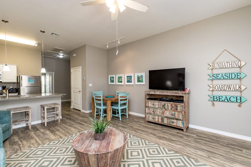 Relax in this bright living area with beach-themed decor, modern kitchen, and coastal charm for your perfect getaway.