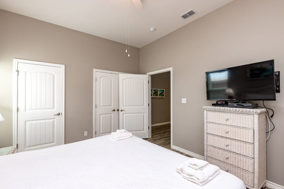 Unwind in your peaceful bedroom featuring a comfortable bed, modern TV, and thoughtful furnishings designed for ultimate relaxation.