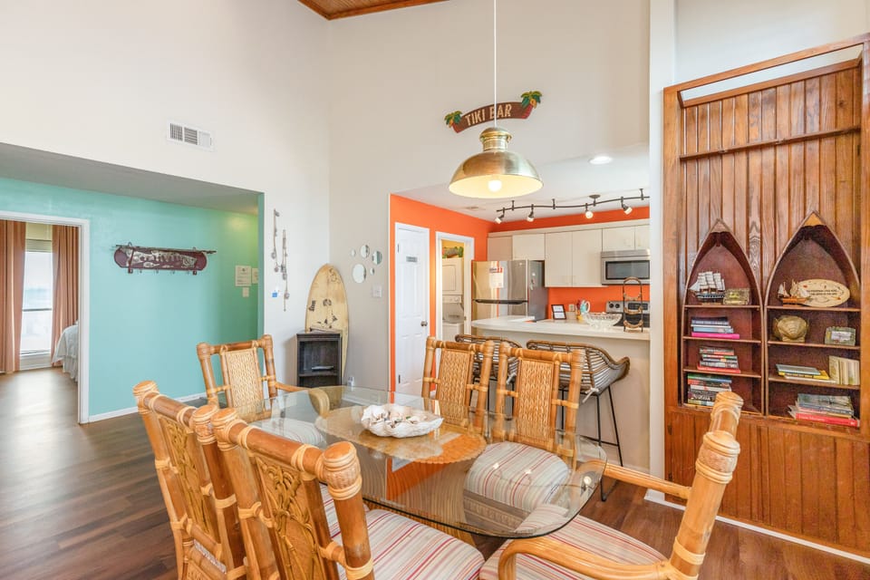 Relax in your coastal-themed living space with warm wood details, tropical decor, and a fully equipped kitchen perfect for vacation meals.
