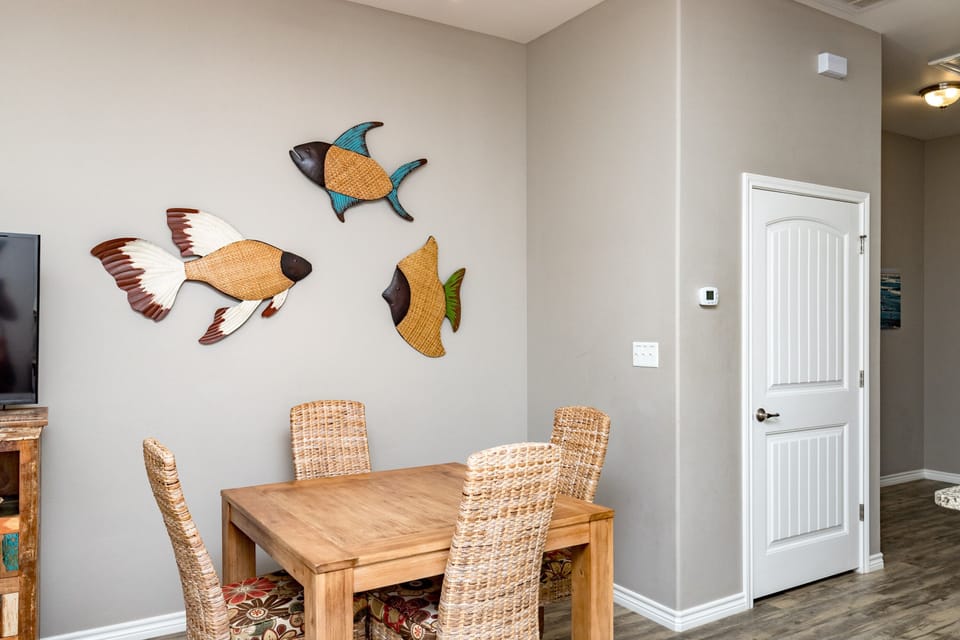 Gather around your charming dining table where whimsical fish art creates a coastal atmosphere for memorable meals together.
