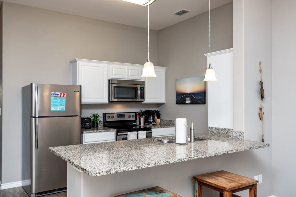 Your modern kitchen features granite countertops, stainless steel appliances, and pendant lighting—perfect for preparing meals during your stay.