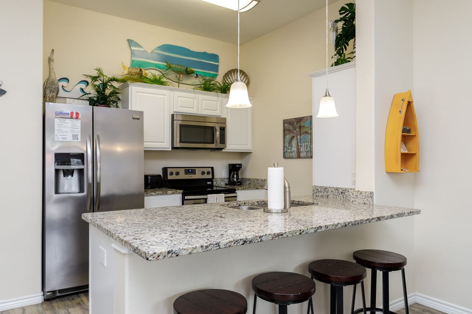 Your fully equipped kitchen features granite countertops, stainless appliances, and a breakfast bar where you can enjoy morning coffee.
