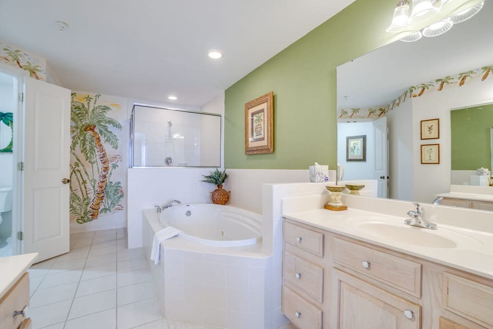 Unwind in your spa-like bathroom featuring a luxurious soaking tub, spacious dual vanities, and tropical-inspired décor.