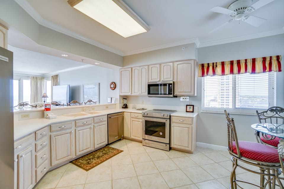 Your fully equipped kitchen awaits with granite counters, stainless appliances, and city views through bright windows.
