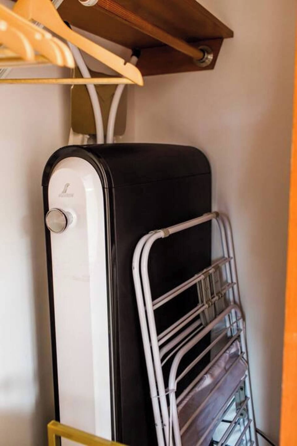 Ironing board, suit cleaner, and drying rack stored in the second bedroom closet.