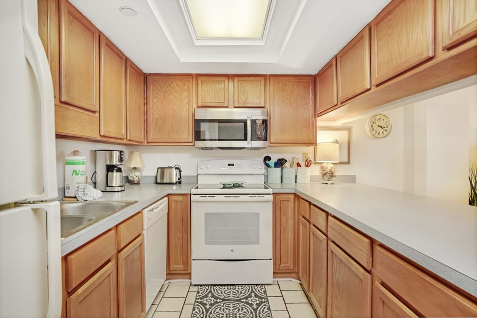 Your fully equipped kitchen features warm wood cabinets, modern appliances, and all the essentials for preparing meals during your stay.