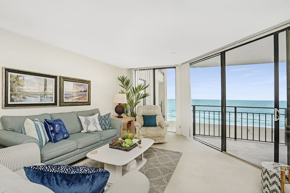 Relax in your oceanfront living room with sweeping sea views through floor-to-ceiling windows and direct balcony access to the waves.