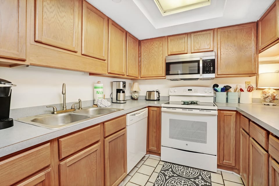 Your fully equipped kitchen awaits with warm wood cabinets, modern appliances, and everything needed to prepare memorable meals during your stay.