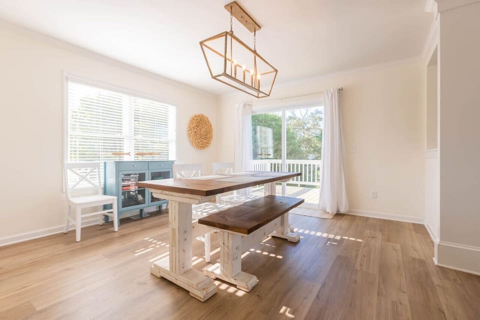 The dining room offers seating for up to 6 people and is just off the kitchen and living room. You can also access the wrap-around deck from here and enjoy some board games in the cabinet!
