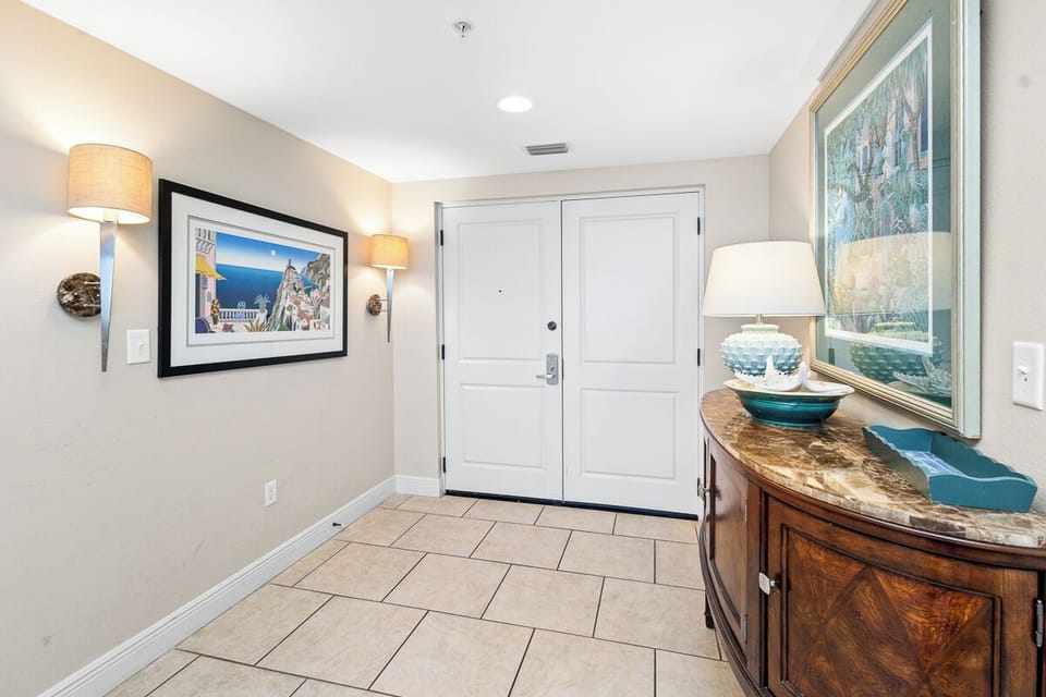 Step into a welcoming entryway with coastal artwork, warm lighting, and stylish accents that make you feel at home the moment you arrive.