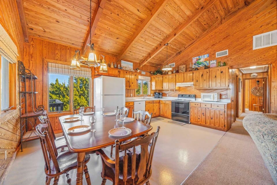 Step into your charming mountain retreat with warm wood beams overhead and a fully equipped kitchen ready for home-cooked meals together.