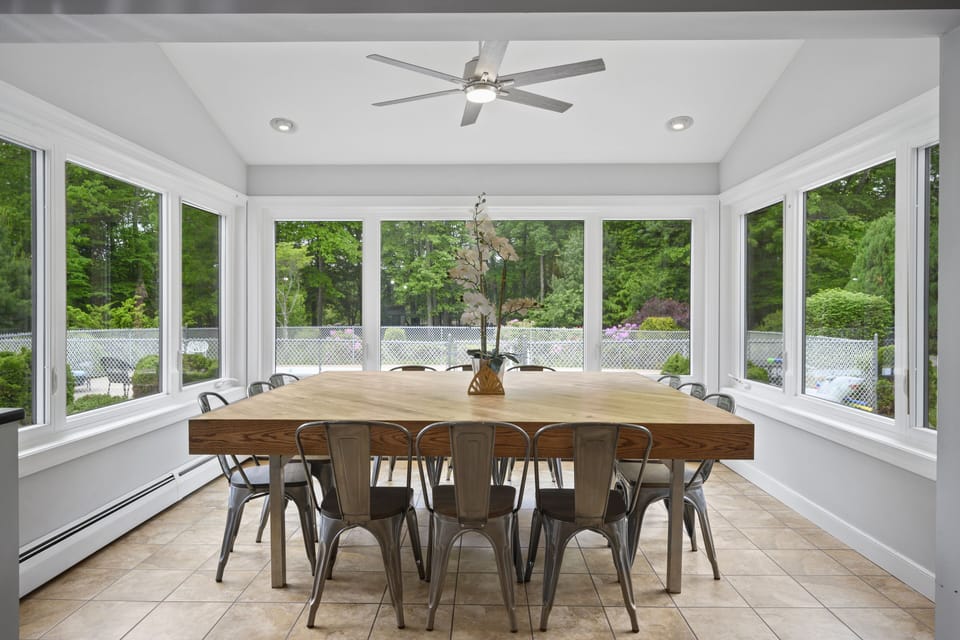 Dining table that seats 14-16 (4 seats on each side) with view of yard and pool 