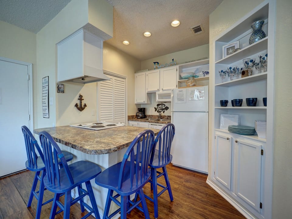 Your coastal-themed kitchen welcomes you with cheerful blue chairs, granite countertops, and nautical touches throughout this fully-equipped space.