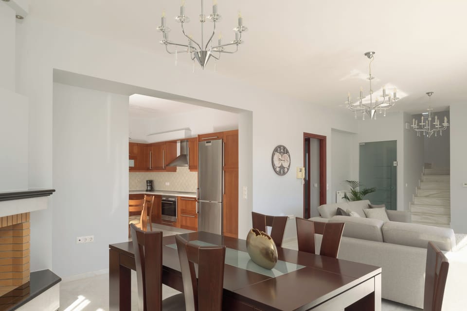 The living room area has an open fireplace and opens to a balcony.