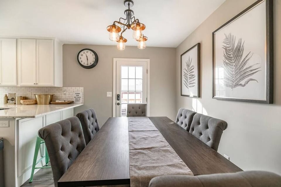 Stylish dining space with a table for six, highlighted by contemporary design elements and wide doors that fill the room with natural light, an ideal spot for enjoying meals together.