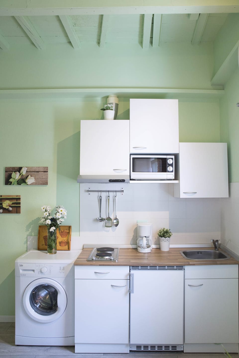 Kitchenette with cooktop, refrigerator, microwave, toaster, coffee maker.
