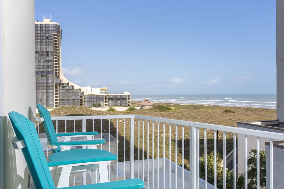 Private balcony has side views of the beach and resort pool.