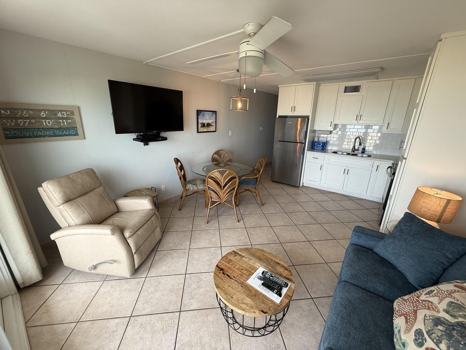 Cozy living room with modern kitchen and relaxing recliner seating
