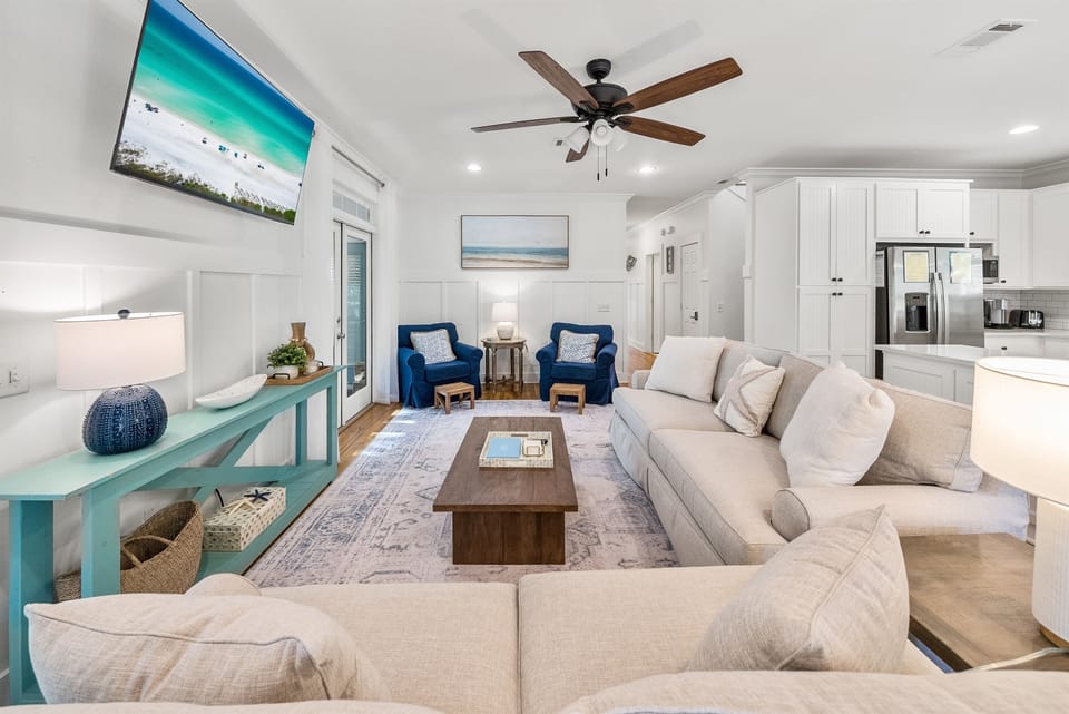 Sink into plush sofas in your open-concept living space, where coastal blues and whites create a serene atmosphere perfect for relaxing.
