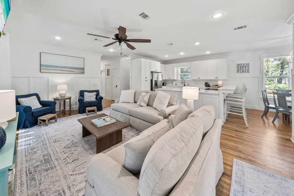 Relax in your bright open-concept living space where plush sofas and modern kitchen flow seamlessly together for perfect vacation gatherings.
