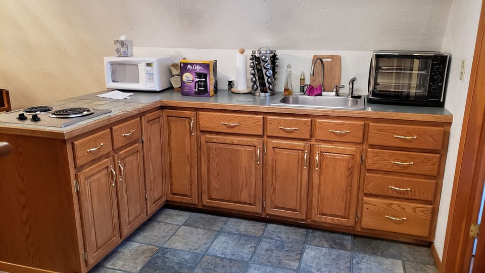 Kitchen with Microwave, large toaster oven, stove. Spice rack, 6 qt Instant Pot.