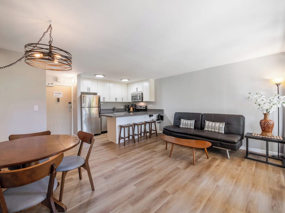 Living Room and Dining Area - Gather in the comfortable living room with a futon sleeper and easy kitchen access—ideal for relaxing between island adventures.
