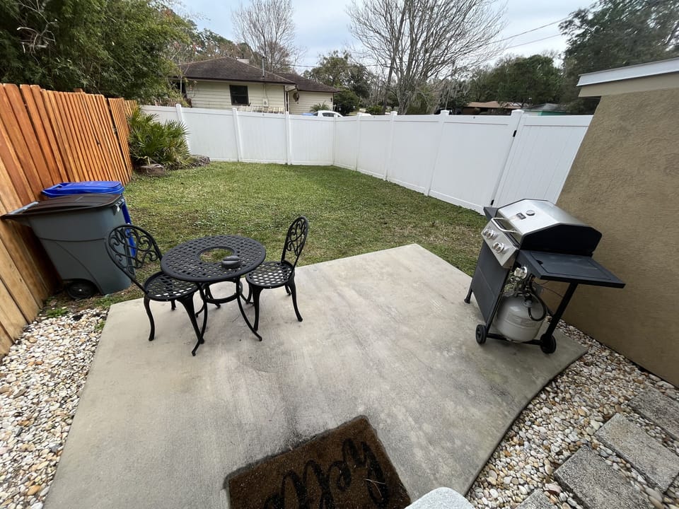 Private pet-friendly fenced backyard with patio seating and grill