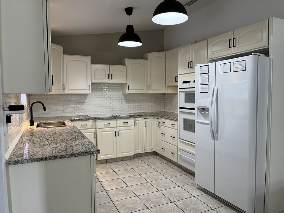 Fully equipped main kitchen with granite counters and ample storage.