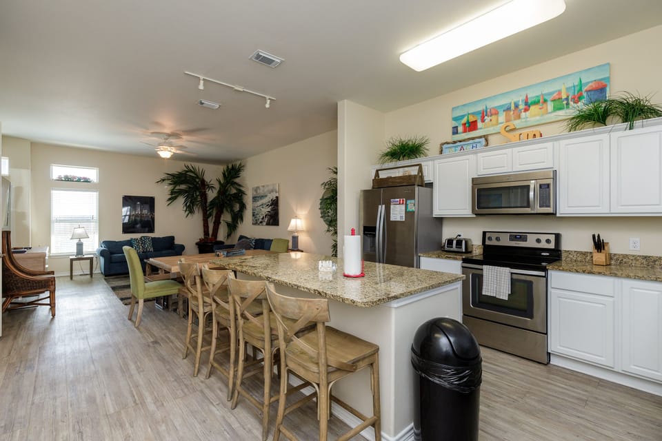 Your open-concept kitchen flows seamlessly into the living area, perfect for cooking while chatting with family around the granite island.