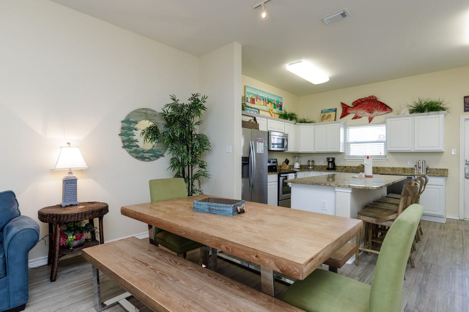 Your open-concept dining area flows into a fully-equipped kitchen, perfect for family meals and coastal-themed relaxation.