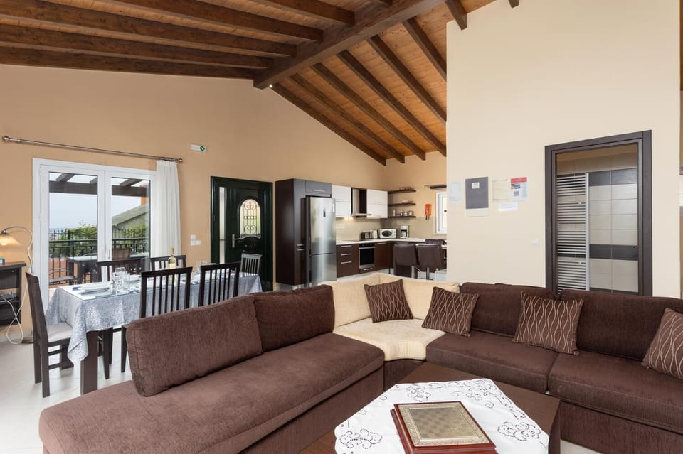 Open-plan living room with sofa, dining area, kitchen, ornamental fireplace, A/C, WiFi internet, satellite TV, and sea views