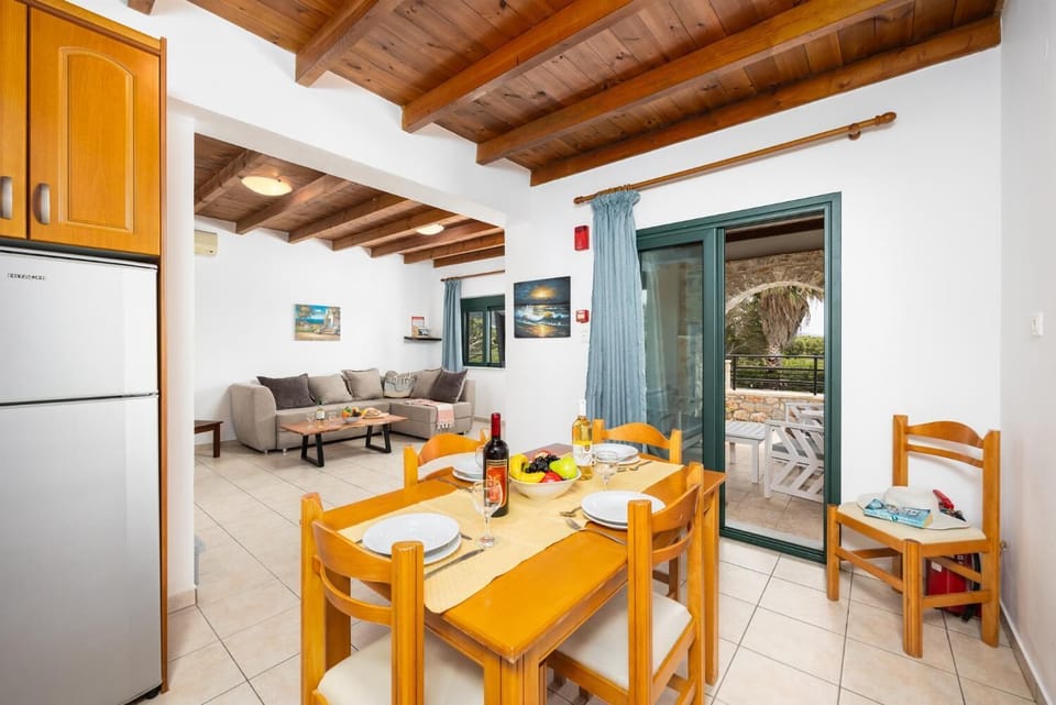 Opne-plan living room with sofa, dining area, kitchen, A/C, WiFi internet, and satellite TV