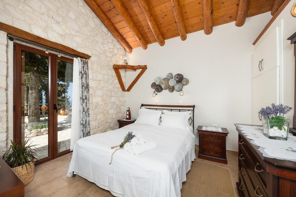 Open-plan villa with sofa, dining area, kitchen, double bed, bathroom, ornamental fireplace, A/C, WiFi internet, satellite TV, and sea views