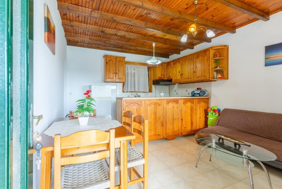 Living room with sofa, dining area, kitchen, and terrace access