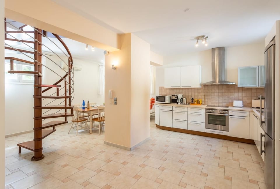 Living area on ground floor with sofa, dining area, kitchen, ornamental fireplace, A/C, and WiFi internet