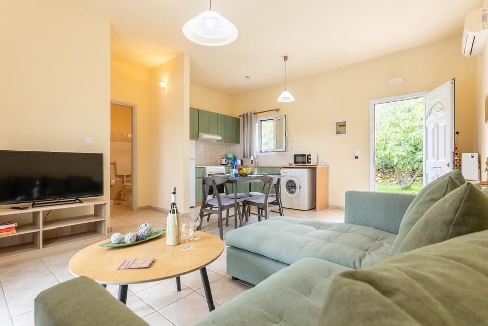 Open-plan living room with sofa, dining area, kitchen, A/C, WiFi internet, and satellite TV