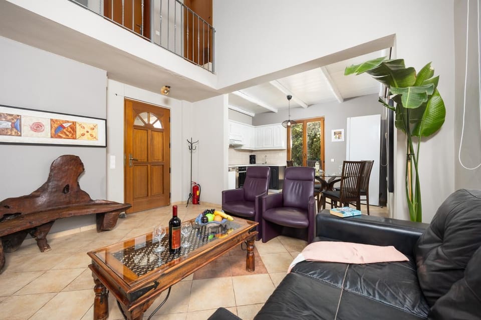 Open-plan living room with sofa, dining area, kitchen, ornamental fireplace, WiFi internet, and satellite TV