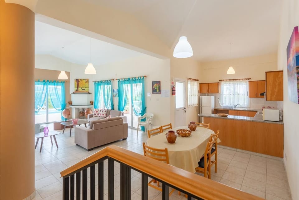 Open-plan living room with sofas, dining area, kitchen, ornamental fireplace, WiFi internet, satellite TV, DVD player, and pool terrace access