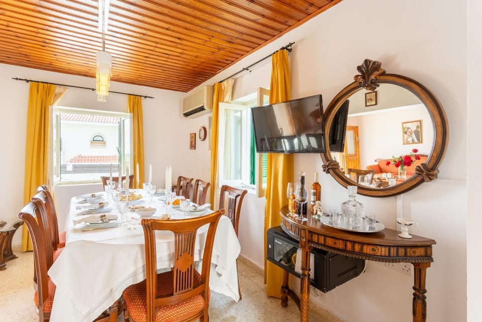 Open-plan living room with sofa, dining area, kitchen, A/C, WiFi internet, and satellite TV