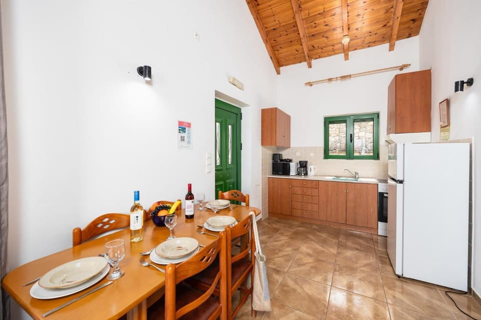 Open-plan living room with sofa, dining area, kitchen, A/C, WiFi internet, and satellite TV