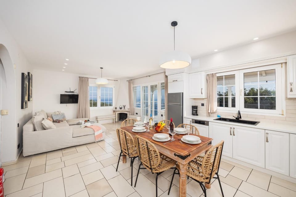 Upper unit: open-plan living room with sofa, dining area, kitchen, ornamental fireplace, WiFi internet, and satellite TV