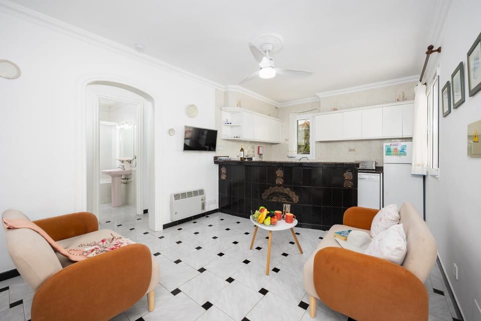 Open-plan living room with sofas, kitchen, WiFi internet, and satellite TV