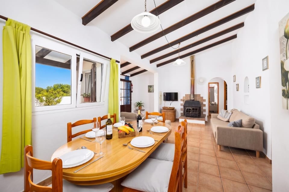 Living room with sofas, dining area, ornamental fireplace, A/C, WiFi internet, and satellite TV