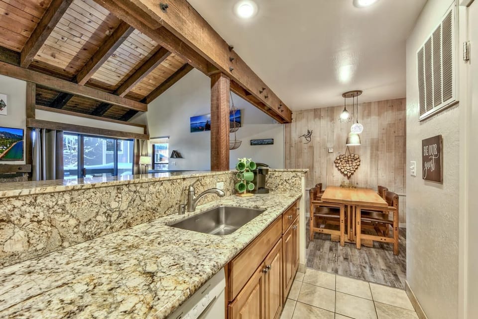Gather around your granite island kitchen with exposed beams overhead, then enjoy meals at your rustic wood dining table.