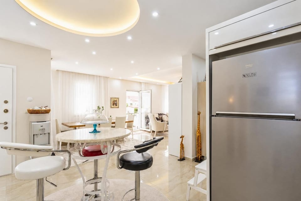 Open-plan living room with sofas, dining area, kitchen, A/C, WiFi internet, satellite TV, DVD player, and pool terrace access