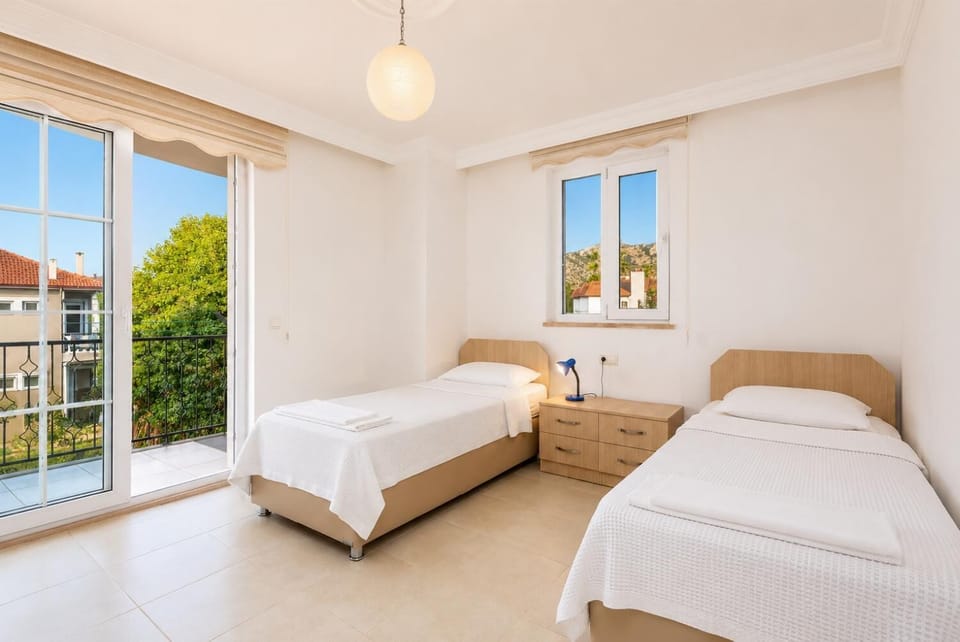 Twin bedroom with en suite bathroom, A/C, and balcony access